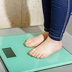 A child’s feet and ankles on a bathroom scale.