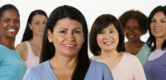A group of diverse women smiles for the camera.