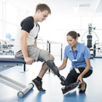 A physical therapist works with a patient with a prosthetic for a below-the-knee amputation.