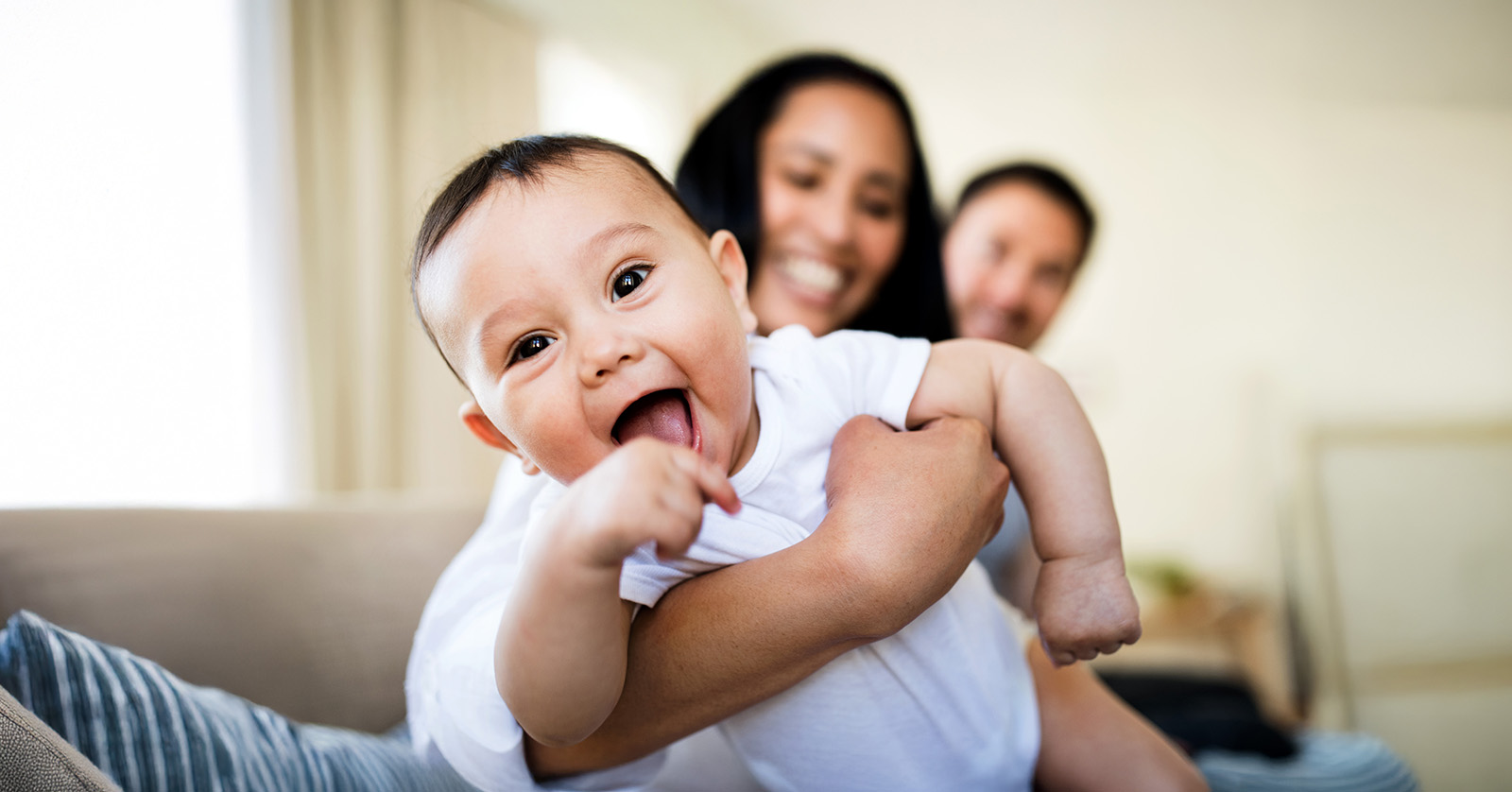 Parents holding smiling baby.