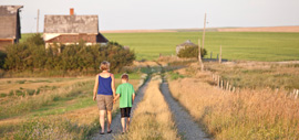 A mother and son walking down a rural road.