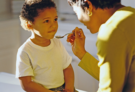 Stock image of child receiving medicine.